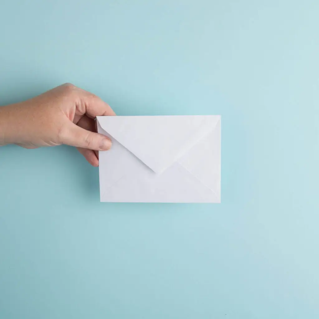 An image of a hand holding an envelope representing Soulheart's blog titled Beyond the Pretty Pixels Digital Marketing Training For Designers/