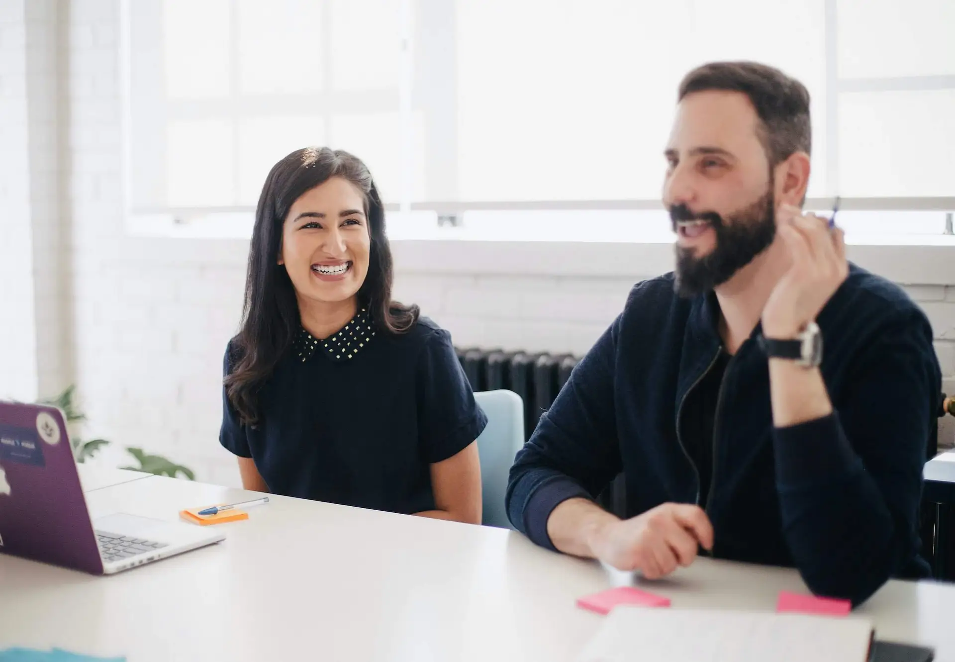 Image of two co workers in a meeting smiling representing Soulheart's blog How Nonprofits Can Run Successful Google Ads [6 Things to Know].