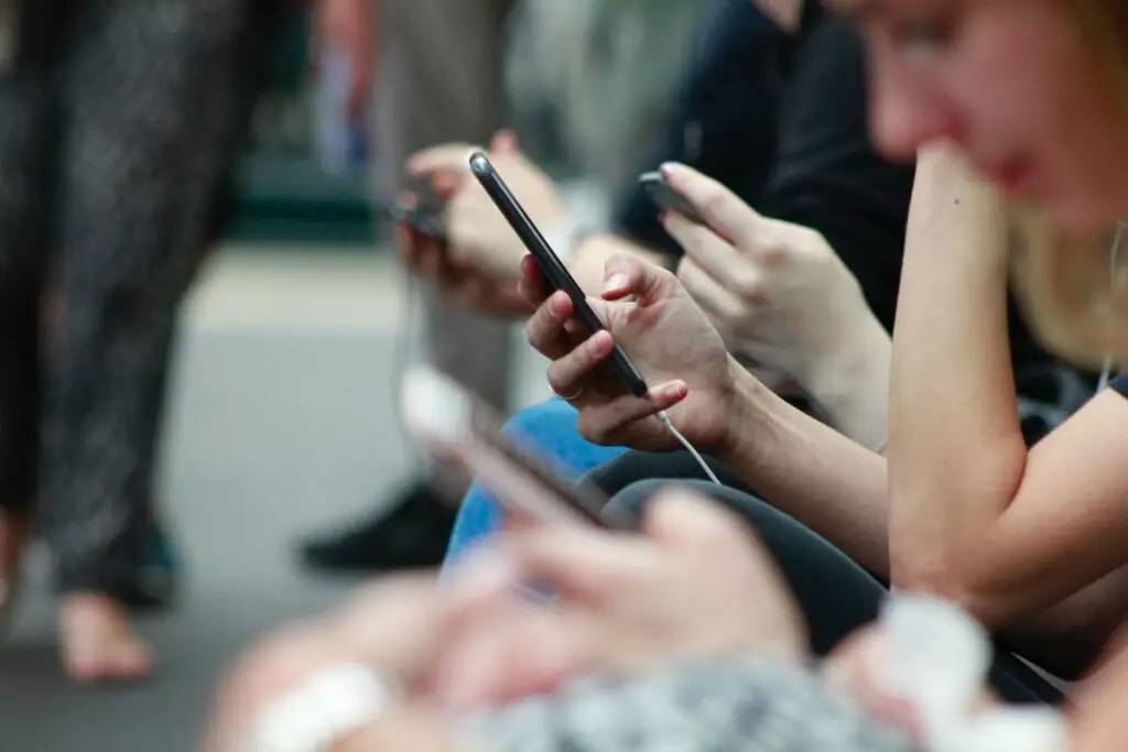 Image of people on a bus on their phone representing Soulheart's blog titled Why Your Website Design Should be Mobile Optimized: Part 1