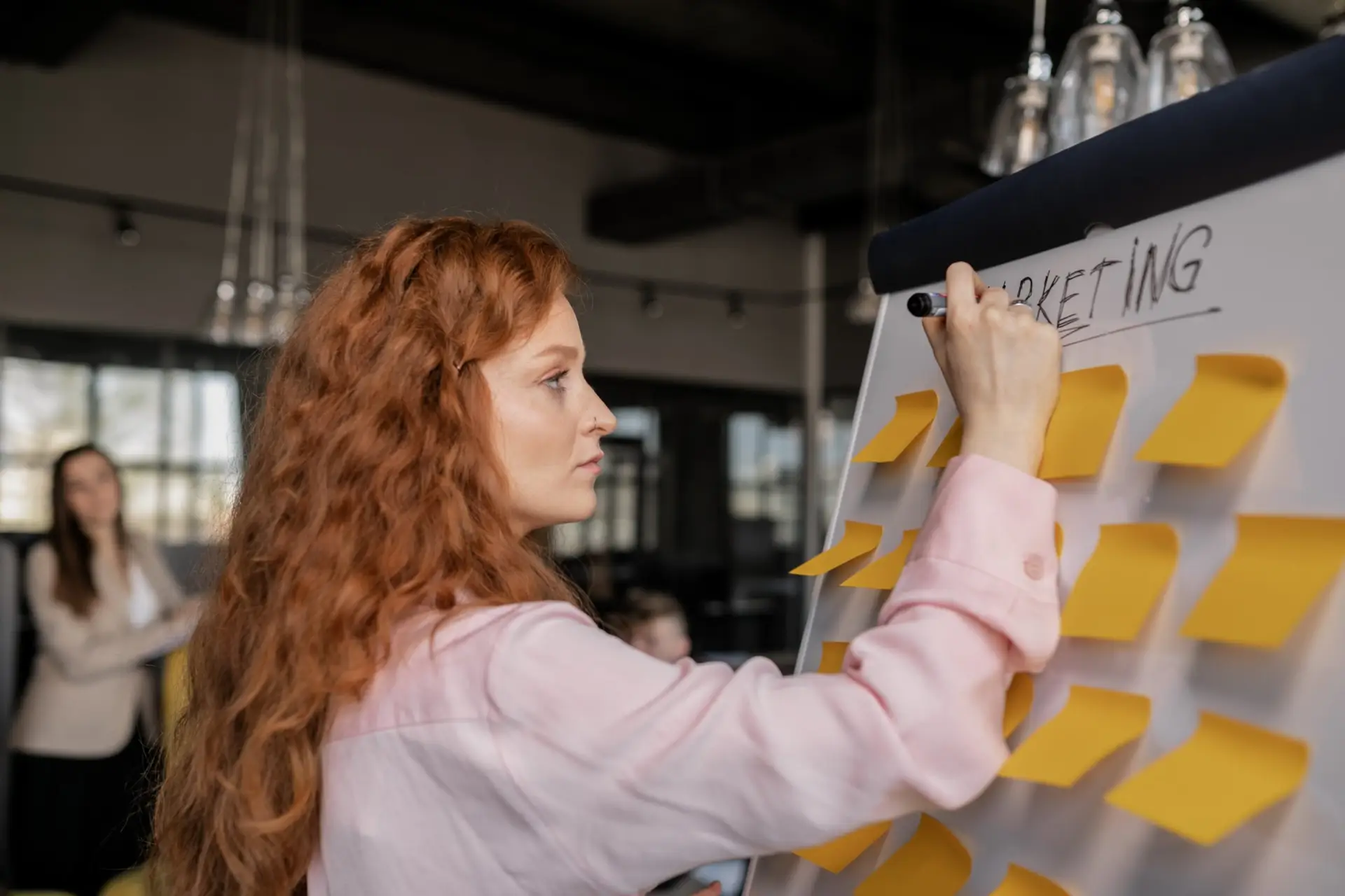 Person writing on sticky notes for digital marketing purposes representing Soulheart's article on digital marketing strategies for Q4.