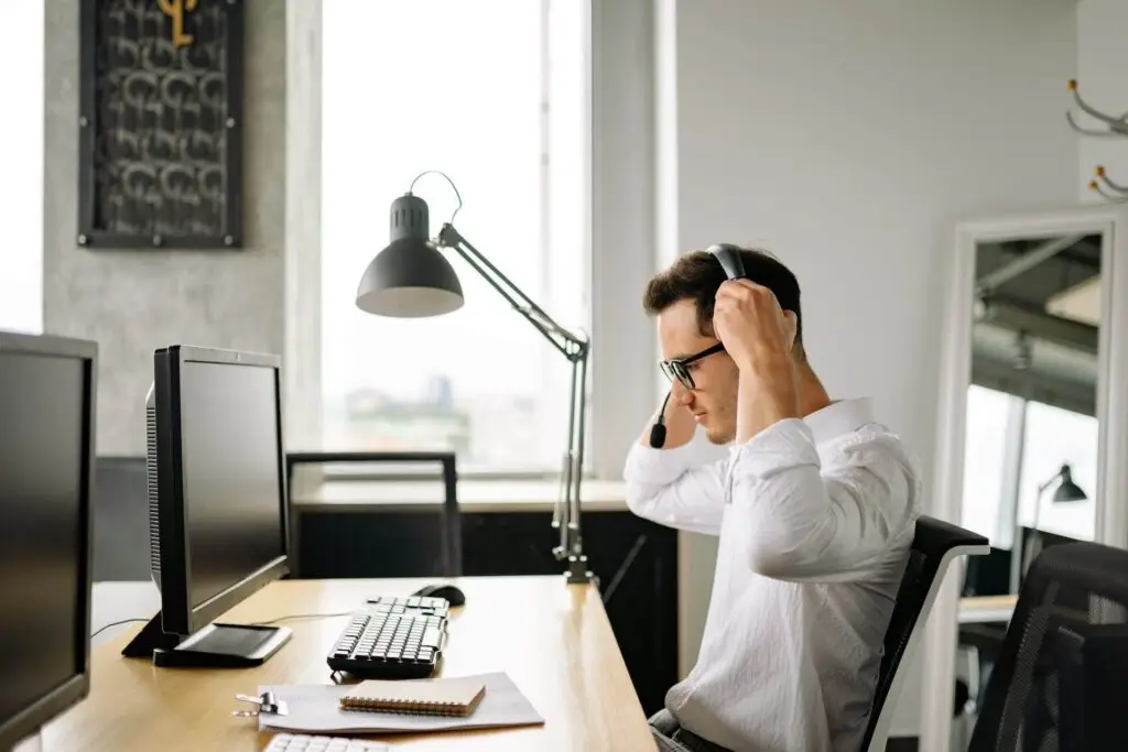 An image of a man in front of his computer putting on a a headset representing Soulheart's blog titled SEO Training for Success: Amplify Your Skills Today.