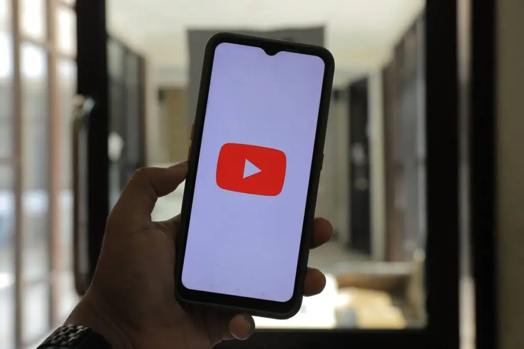 An image of the YouTube logo on a phone screen representing Soulheart's blog titled YouTube Bumper Ads: Captivating Audiences in a Snap.
