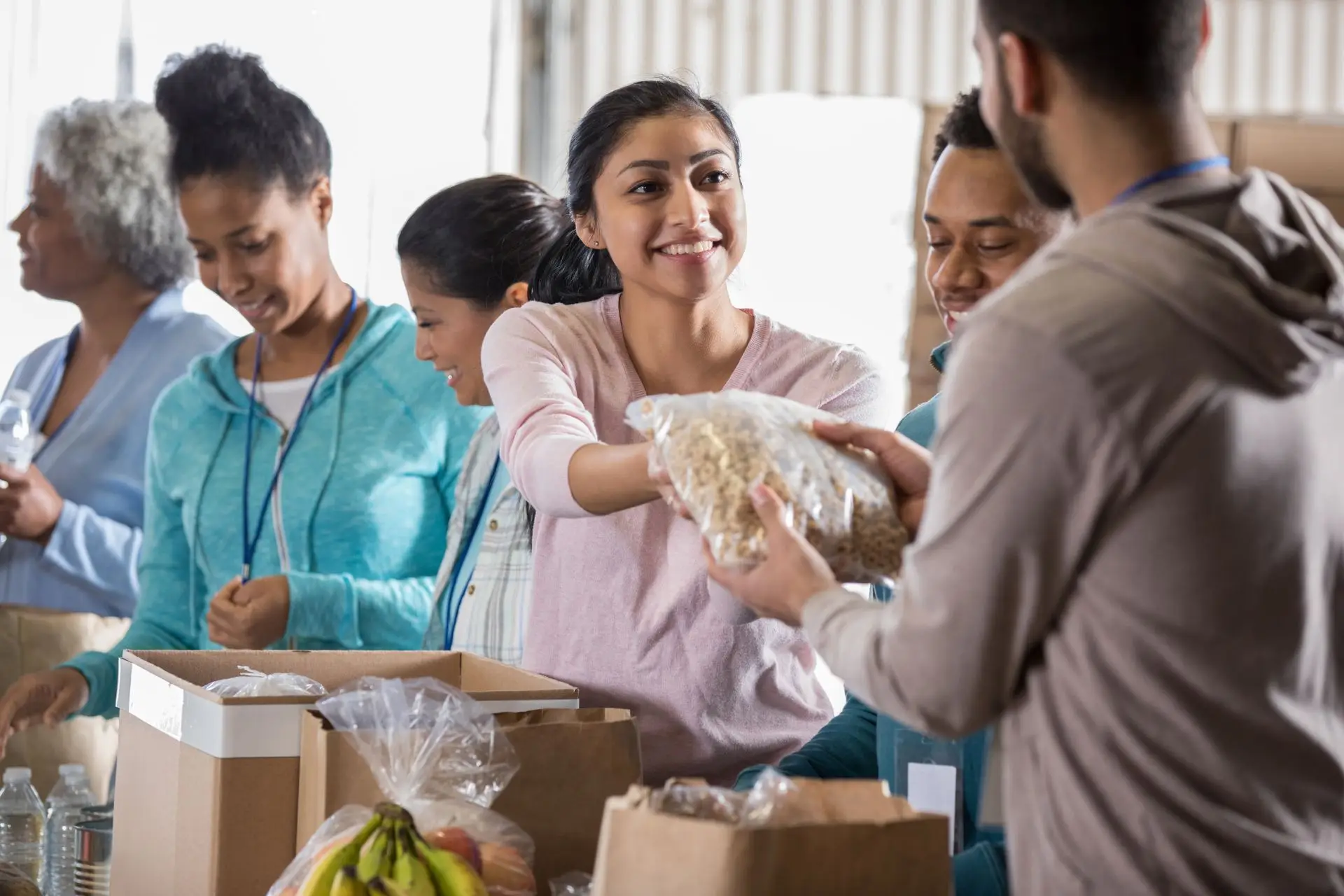 An image of volunteers at a food packing event representing Soulheart's blog on nonprofit volunteer recruitment. The goal is to teach nonprofits how to recruit volunteers.