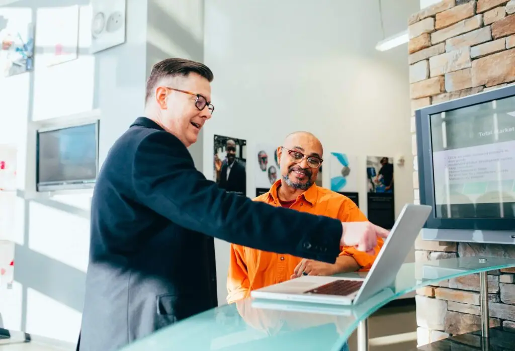 An image of two men looking at a computer representing Soulheart's blog titled Content Excellence: 5 Benefits of Working with Digital Marketers.