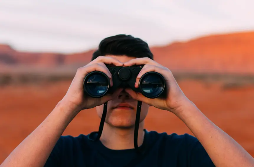 Contenet and SEO What You Need To Know. SEO Tips. Search Engine Optimization. seo. search engine optimization tips. Image of a man standing in the desert looking through binoculars.