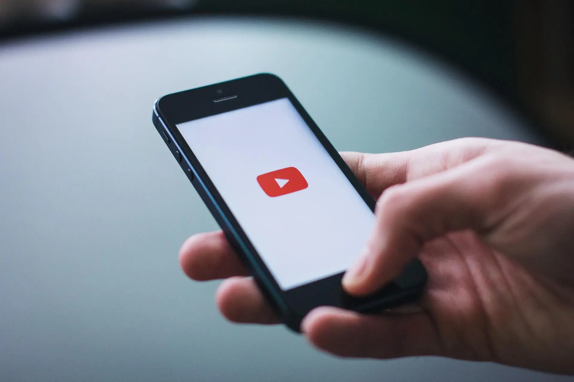 An image of a person watching YouTube on his phone representing Soulheart's blog titled Mastering YouTube Strategy.