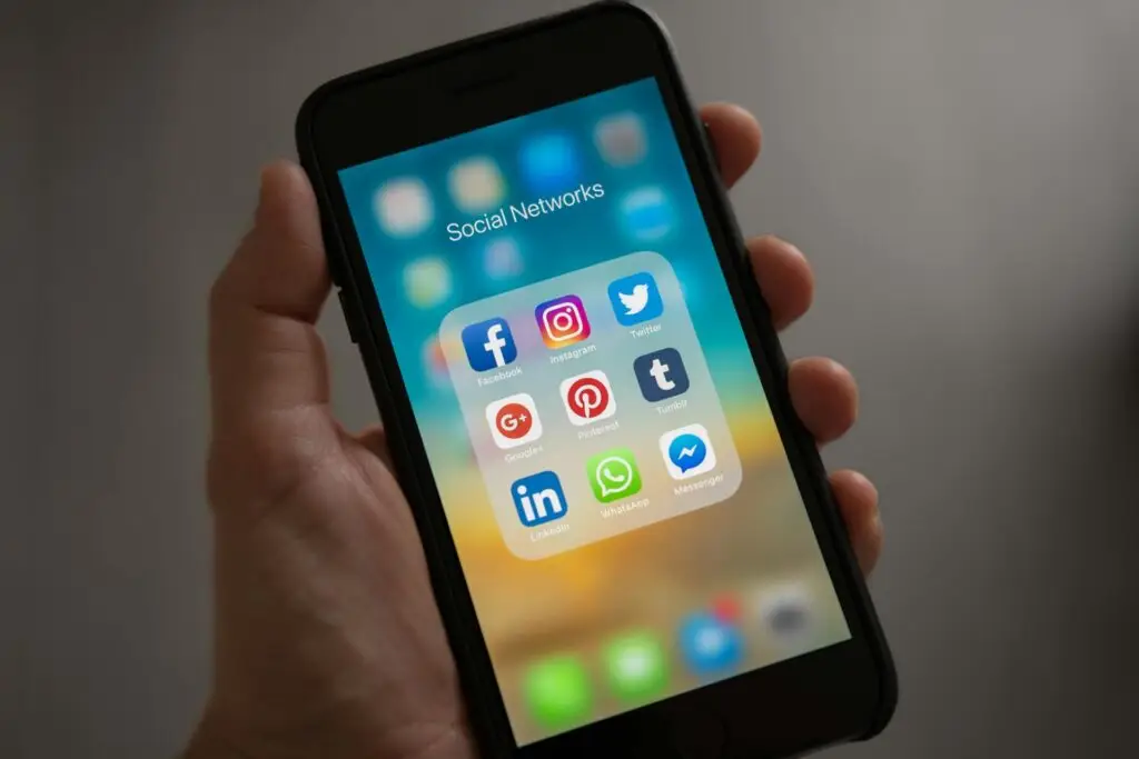 An image of someone holding a smart phone with multiple social media icons on the screen, representing Soulheart's blog titled Advance Your Career - Social Media Training For Digital Marketers