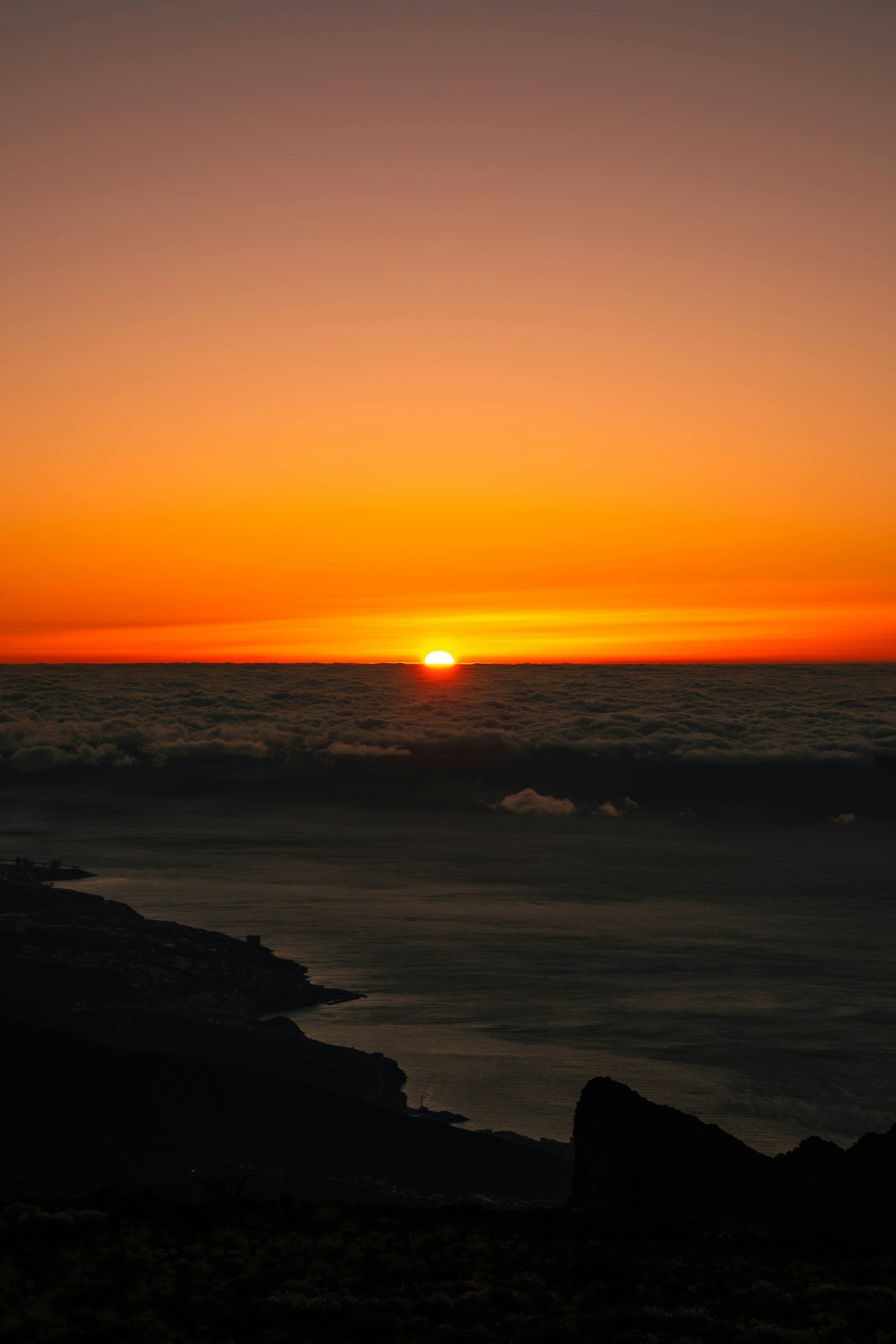 The sun sets over a sea of clouds.