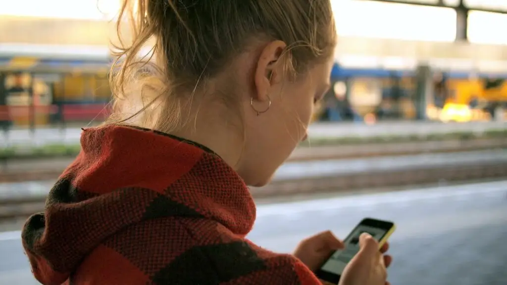 Image of a woman on her phone representing Soulheart's blog titled Why Your Website Design Should be Mobile Optimized: Part 1.