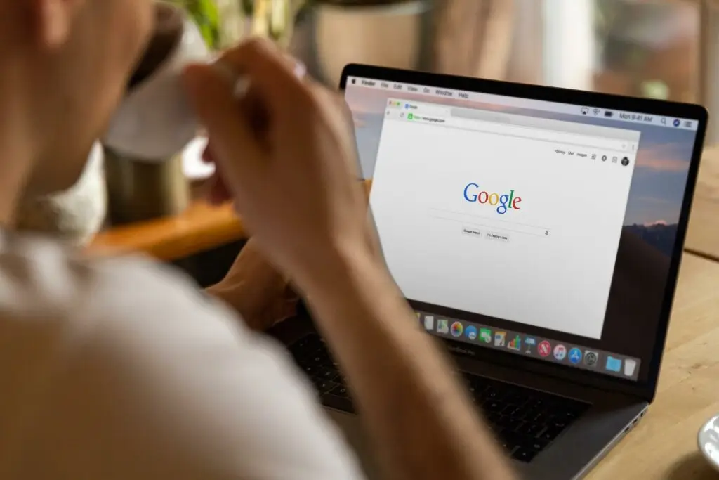 Image of a man sitting in front of his laptop with Google open, representing Soulheart's blog titled Optimizing Your Blog for Search Engines.