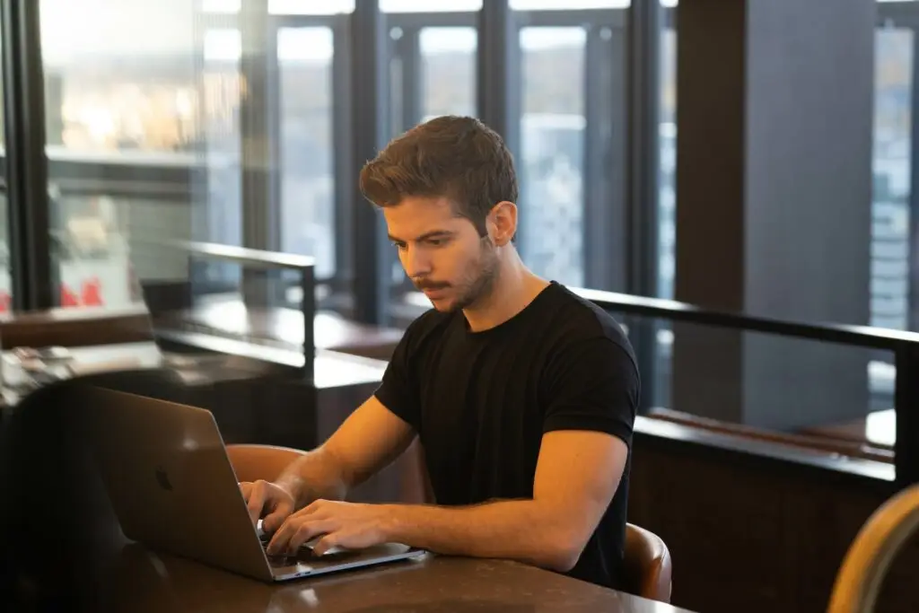 An image of a man typing on his laptop representing Soulheart's blog titled A Nonprofit's Comprehensive Guide on Google Ads.