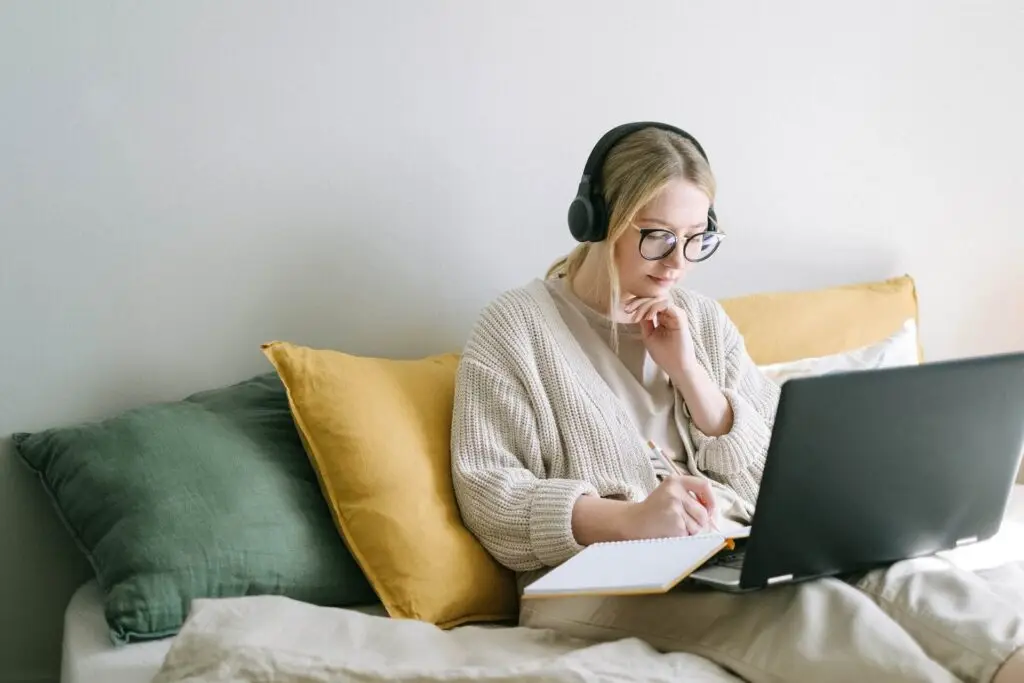 An image of a woman taking notes in front of her laptop representing Soulheart's blog titled SEO Training for Success: Amplify Your Skills Today.
