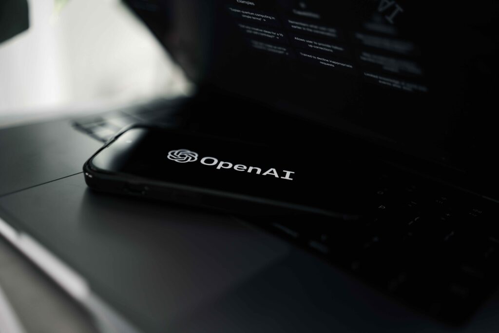 Image of a black laptop open with ChatGPT's parent company Open.ai on the computer. The image represents Soulheart's article: The Beginner's Guide to ChatGPT for SEO.