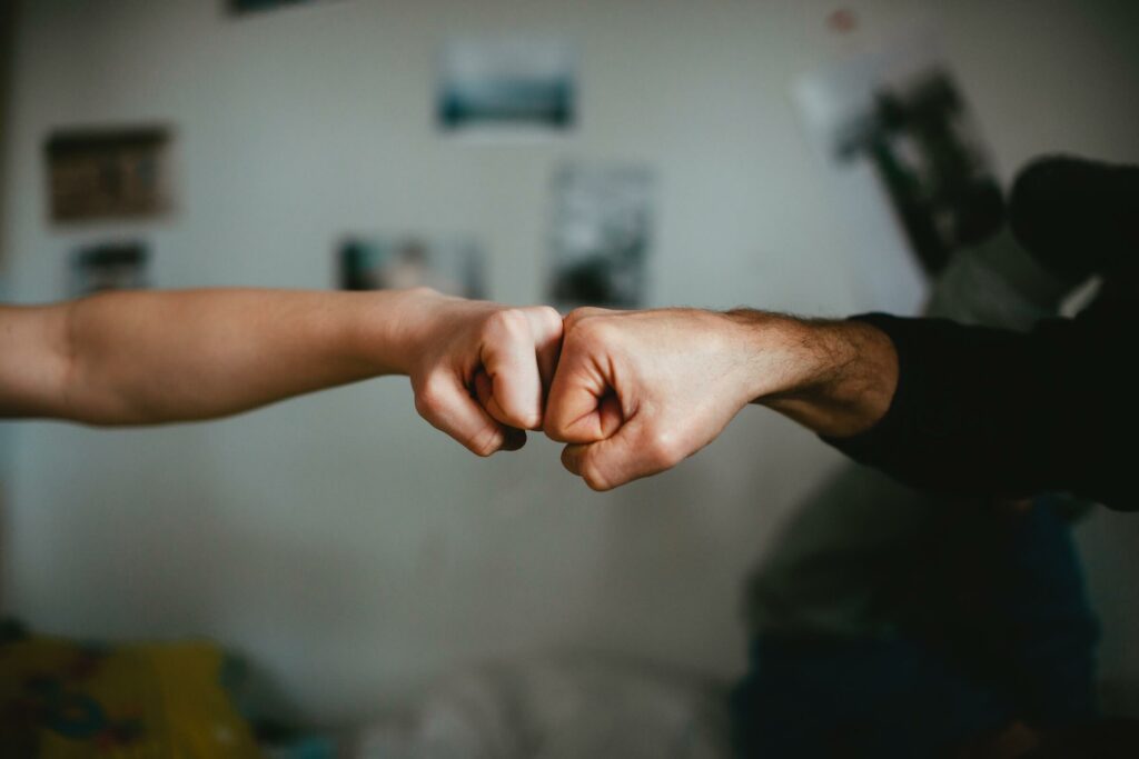 An image of two people fist bumping representing Soulheart's blog "Leveraging AI for Google Ads: A Guide for Nonprofit Organizations"